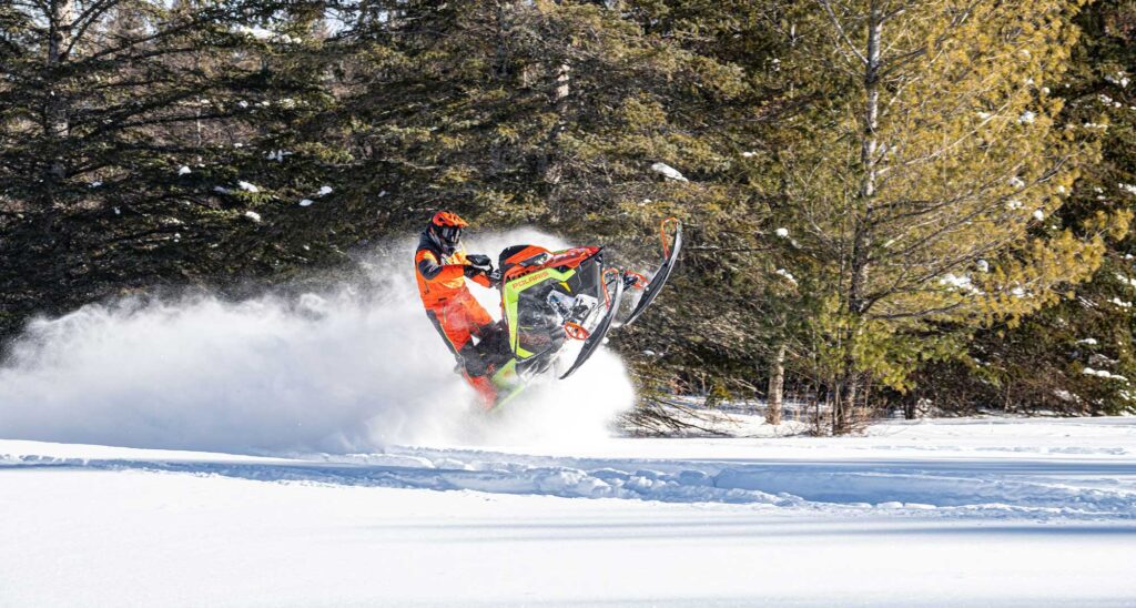 A dynamic image capturing the excitement and motion of a Polaris snowmobile in action jumping in the snow highlighting Hi-Torque Rollers for the secondary snowmobile clutch.